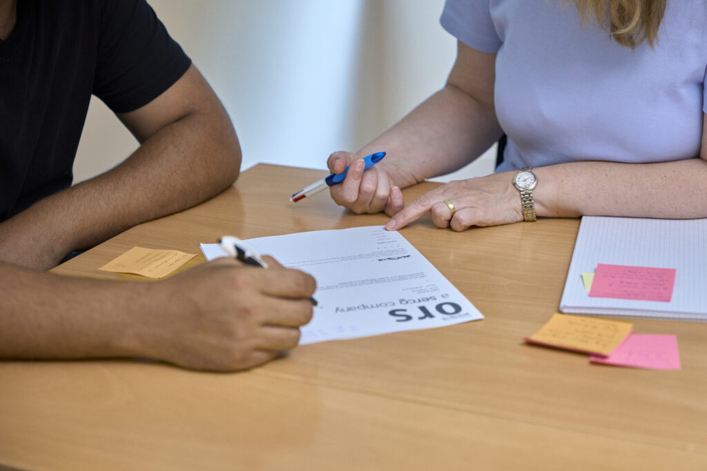 Conseillère en insertion : mobiliser les ressources et créer des ponts vers l’emploi 10 Emploi Lausanne | Conseillère en insertion : mobiliser les ressources et créer des ponts vers l’emploi Gros plan sur les mains de 2 personnes discutant d'un dossier