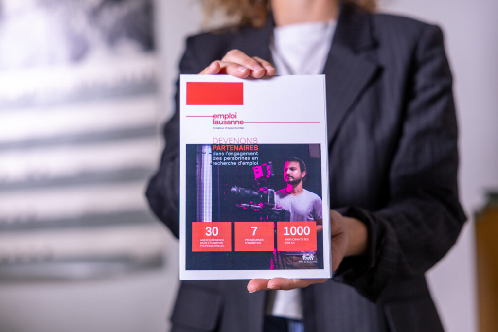 Conseillère en insertion : mobiliser les ressources et créer des ponts vers l’emploi 12 Emploi Lausanne | Conseillère en insertion : mobiliser les ressources et créer des ponts vers l’emploi Gros plan sur la brochure emploi lausanne tenue par une femme